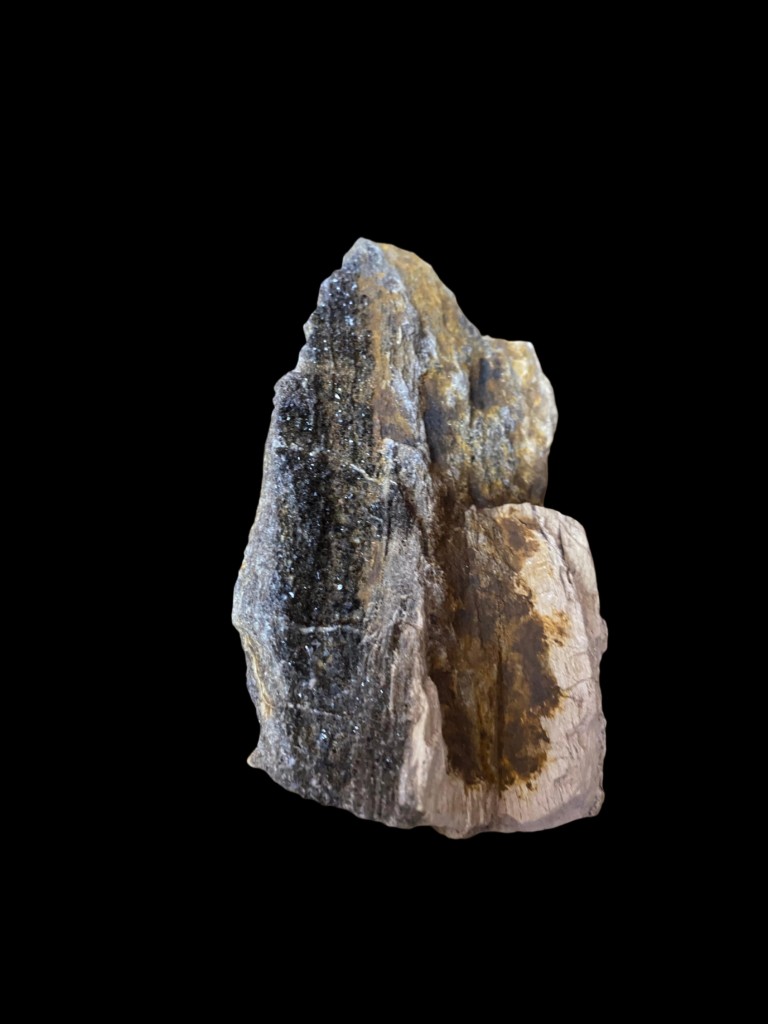 Superficie con microcristales y tonos ámbar en matriz oscura